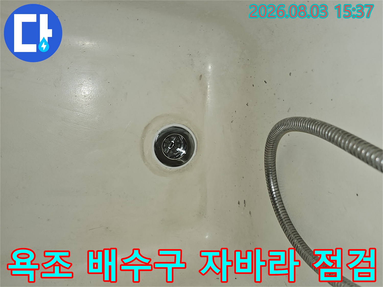 욕조 내부에 연결된 은색 자바라 배수관과 하수구 배출구 모습