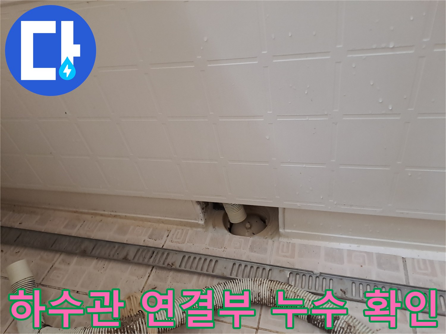 타공된 점검구 내부의 배수 호스와 바닥 하수관 연결 부위