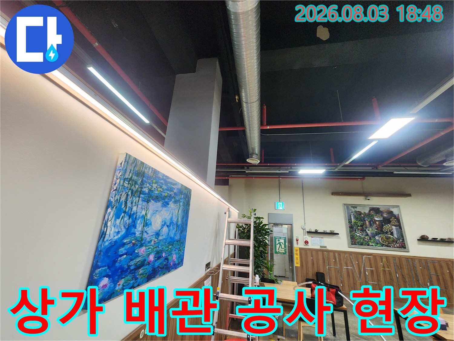 노출된 상가 천장 배관과 작업용 사다리가 있는 누수 공사 현장