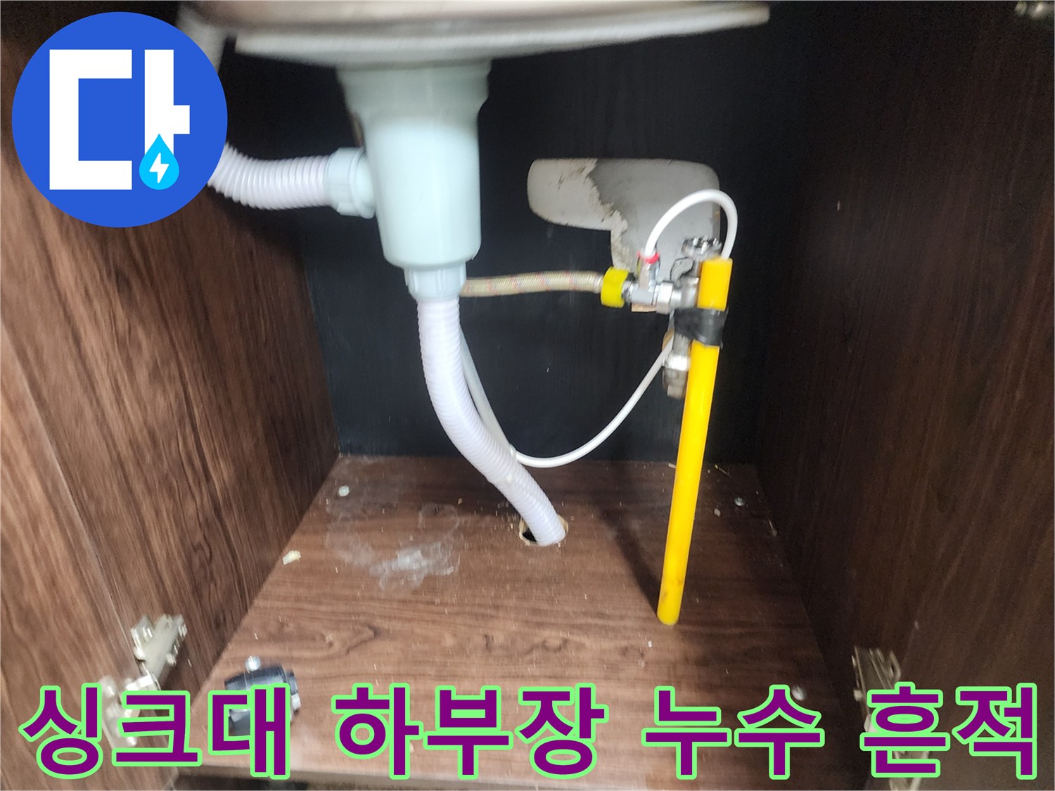 물기로 인해 오염된 싱크대 하부장 바닥과 배수 호스 연결 부위