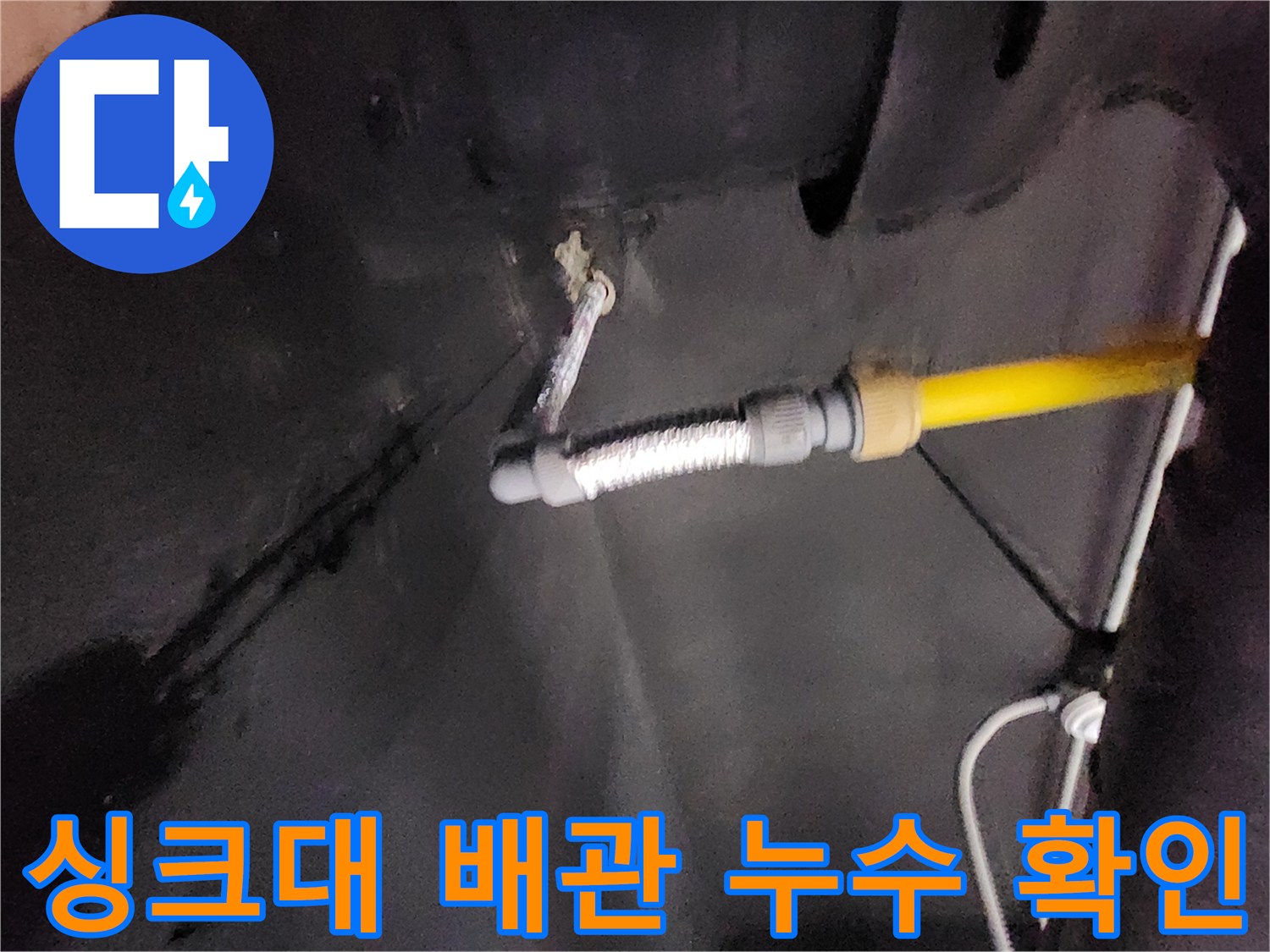 싱크대 하부장 내부-배수 호스와 벽면 관통 부위의 물샘 흔적