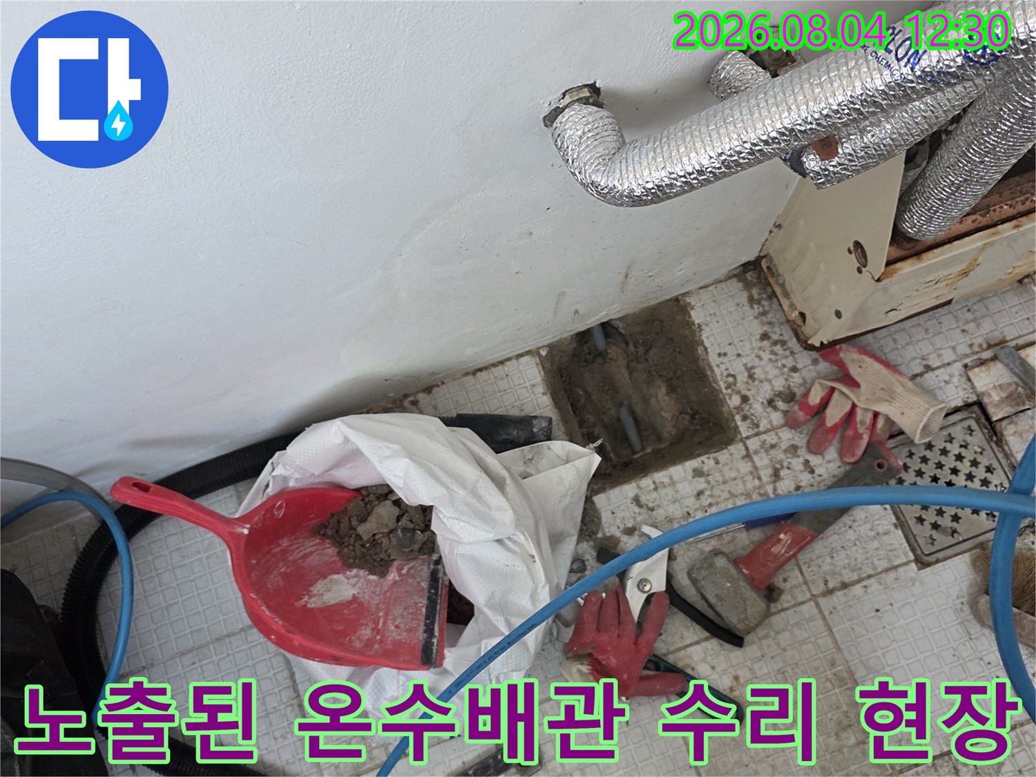 파손된 벽면을 굴착하여 노출시킨 온수배관과 수리용 장비들