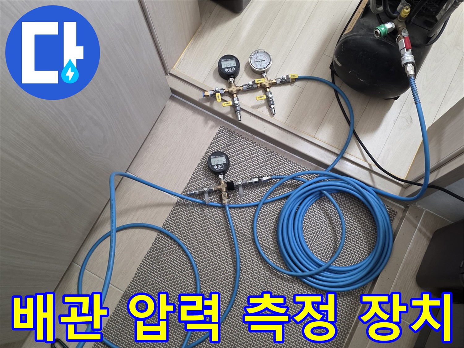 바닥 타일 위에 배치된 배관 공압 테스트용 게이지와 호스