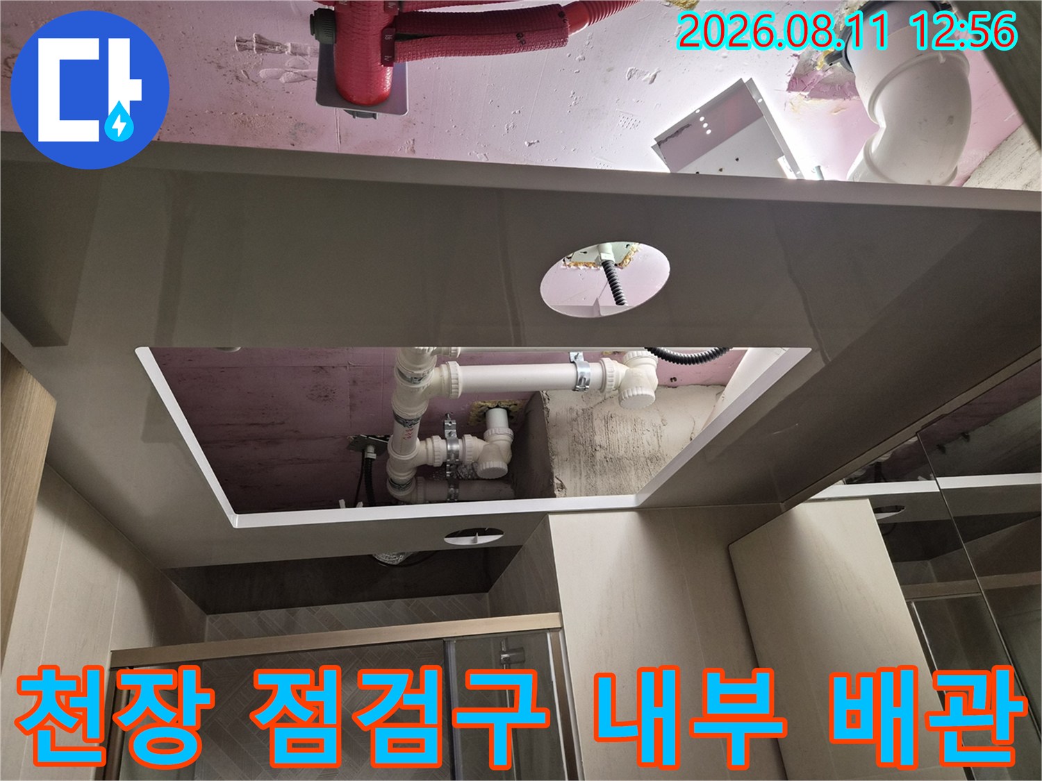 천장 점검구를 통해 보이는 하얀색 배관과 분홍색 슬라브 구조물