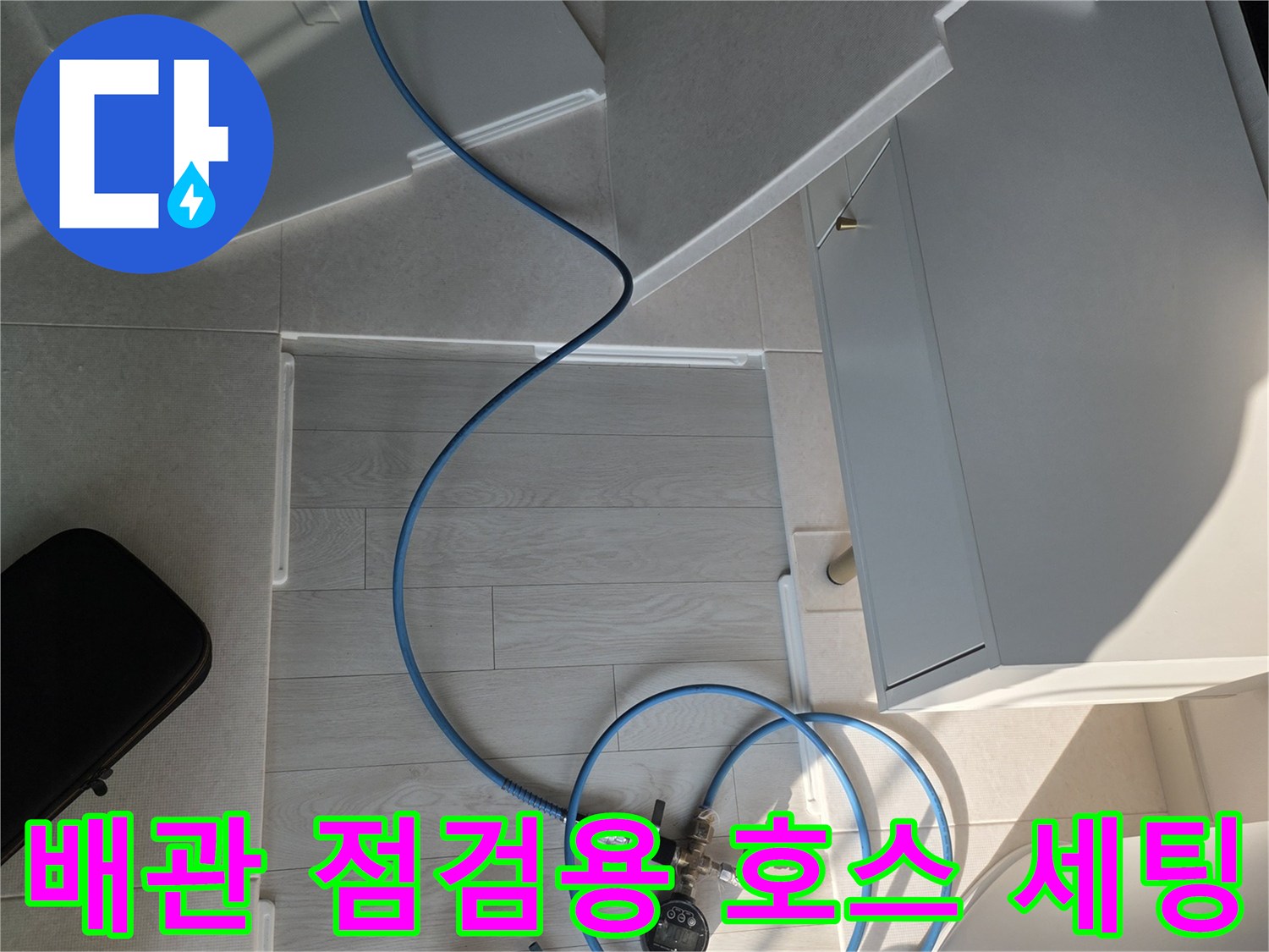 바닥에-펼쳐진-파란색-배관-점검용-호스와-측정-도구