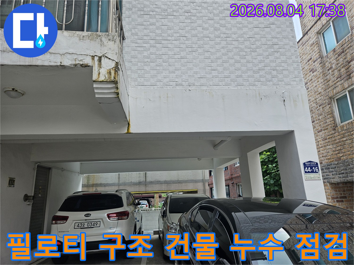 필로티 구조 건물의 외부와 주차 공간이 보이는 현장 진입로 모습