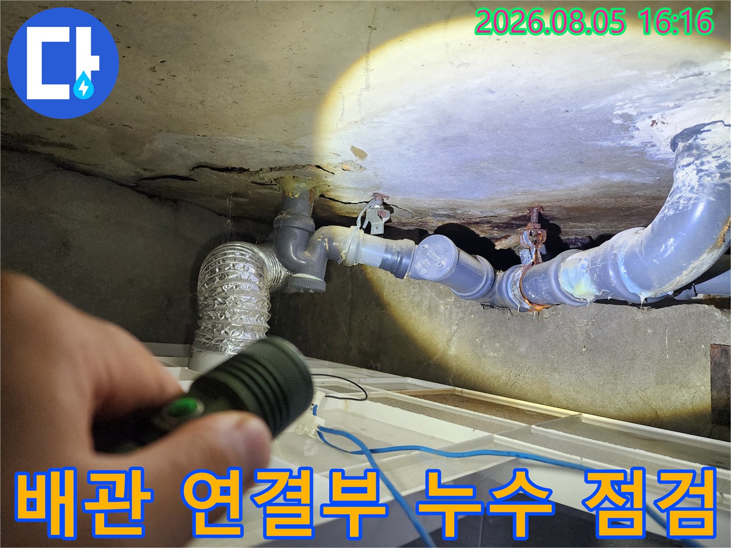 손전등 조명 아래 노출된 배관 부위 세밀 검사