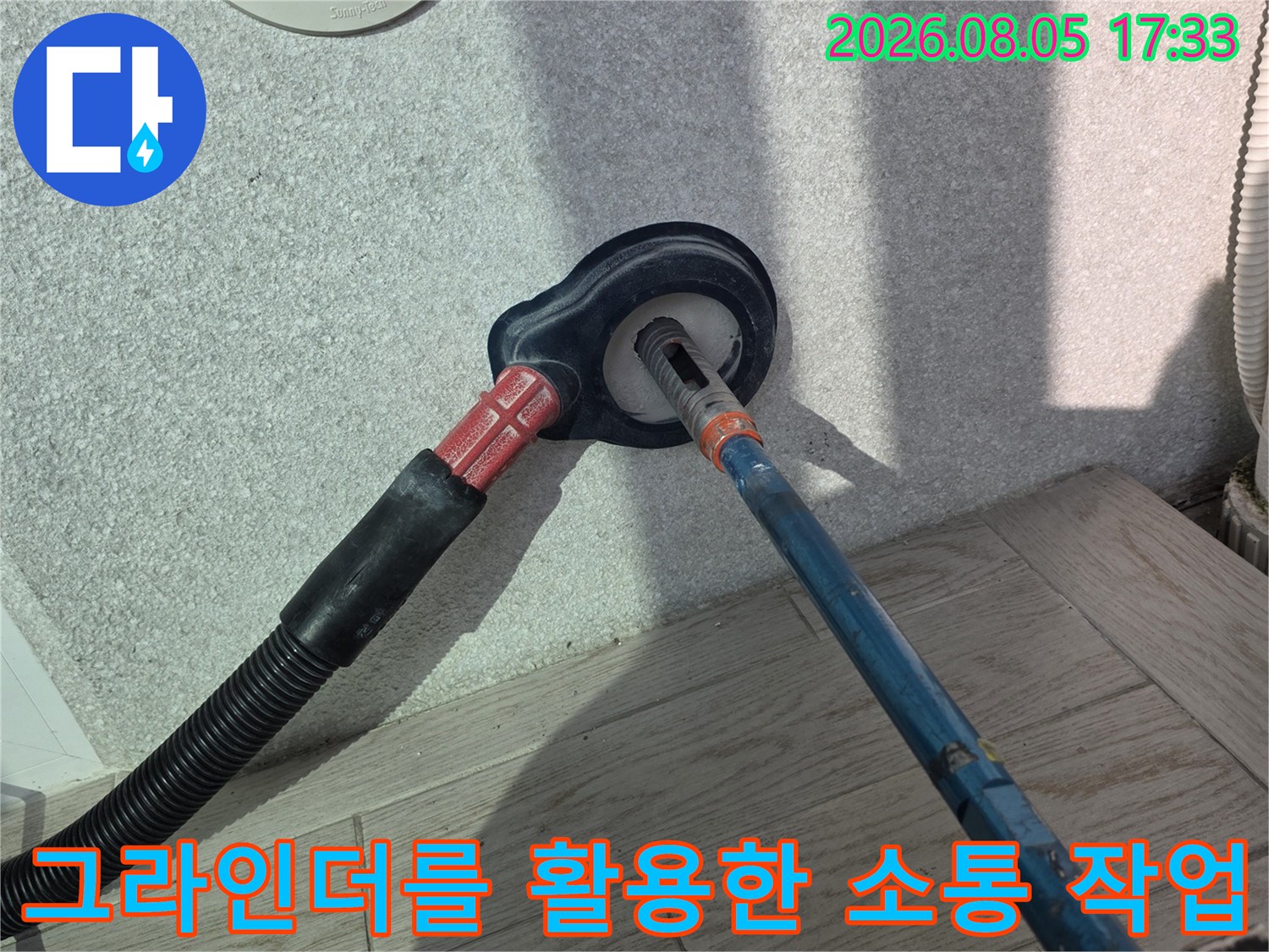 그라인더 장비를 사용하여 세탁실 배수구의 막힌 구간을 뚫어내는 전문 작업 모습