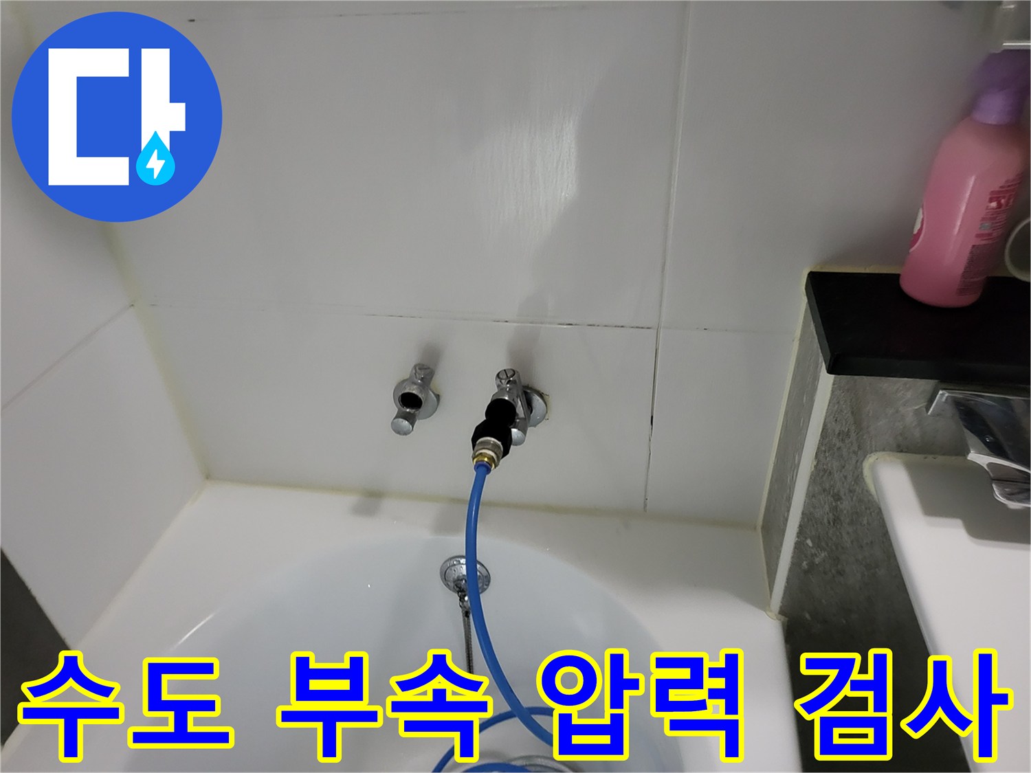 욕실 벽면 수전 부위-공압 장비를 연결하여 배관 점검 중