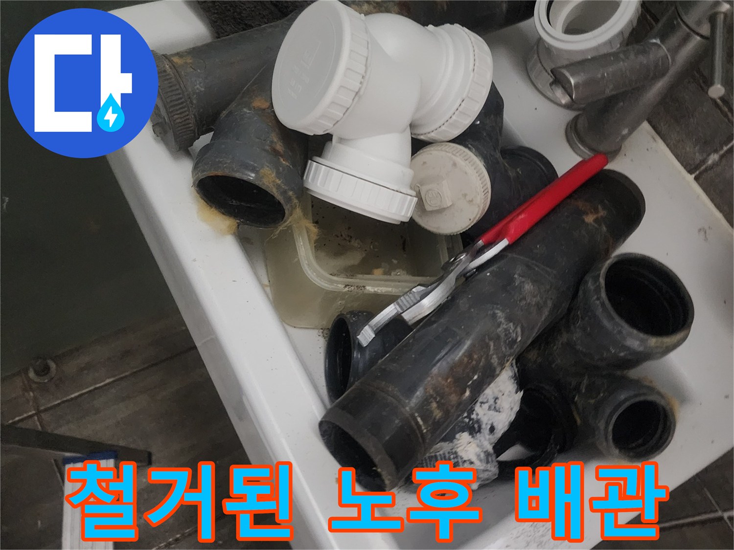 누수가 발생하여 철거된 오래된 검정색 하수관과 새 부속품