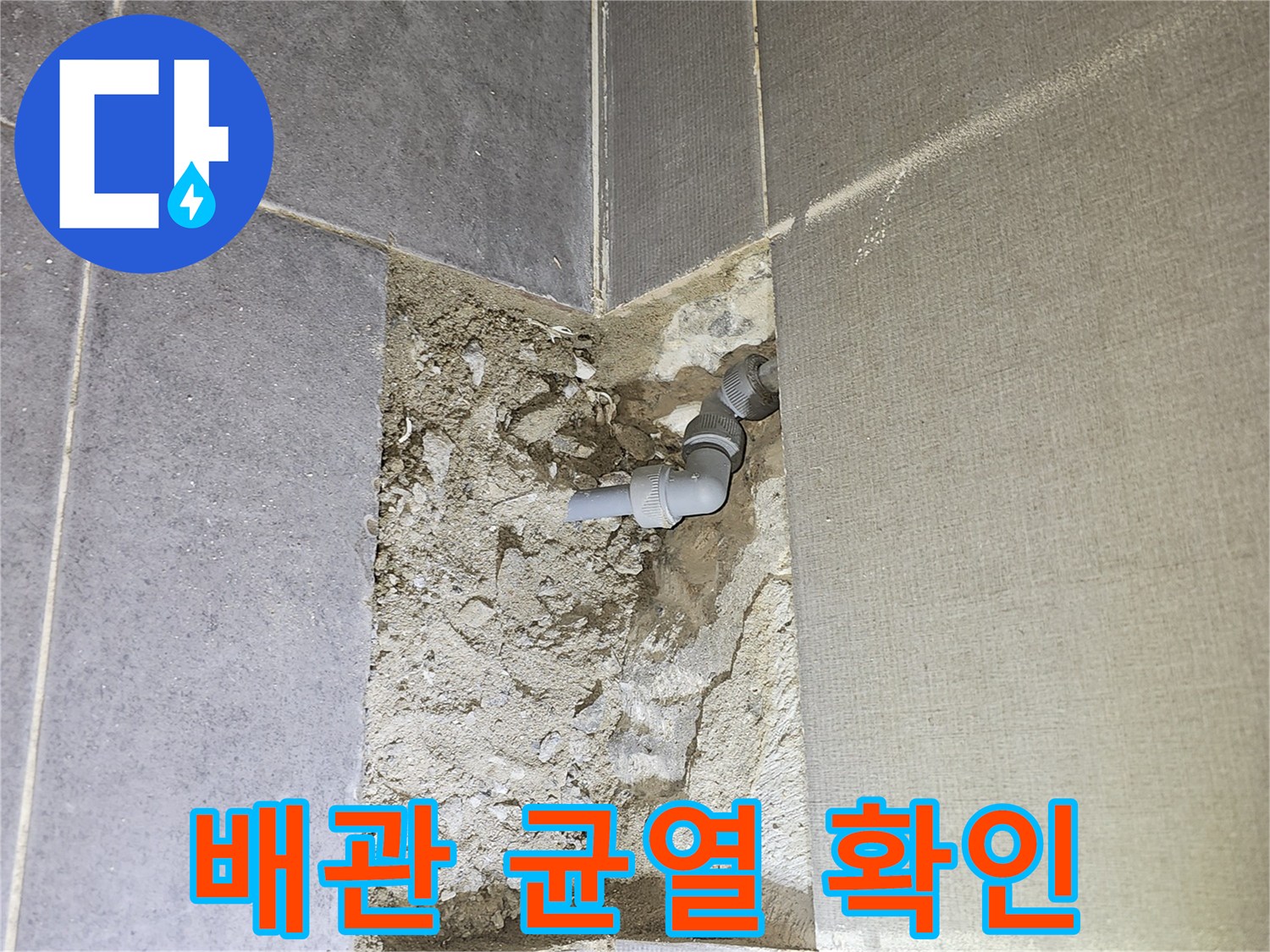 타일 제거 부위-균열이 발생한 회색 배관 노출