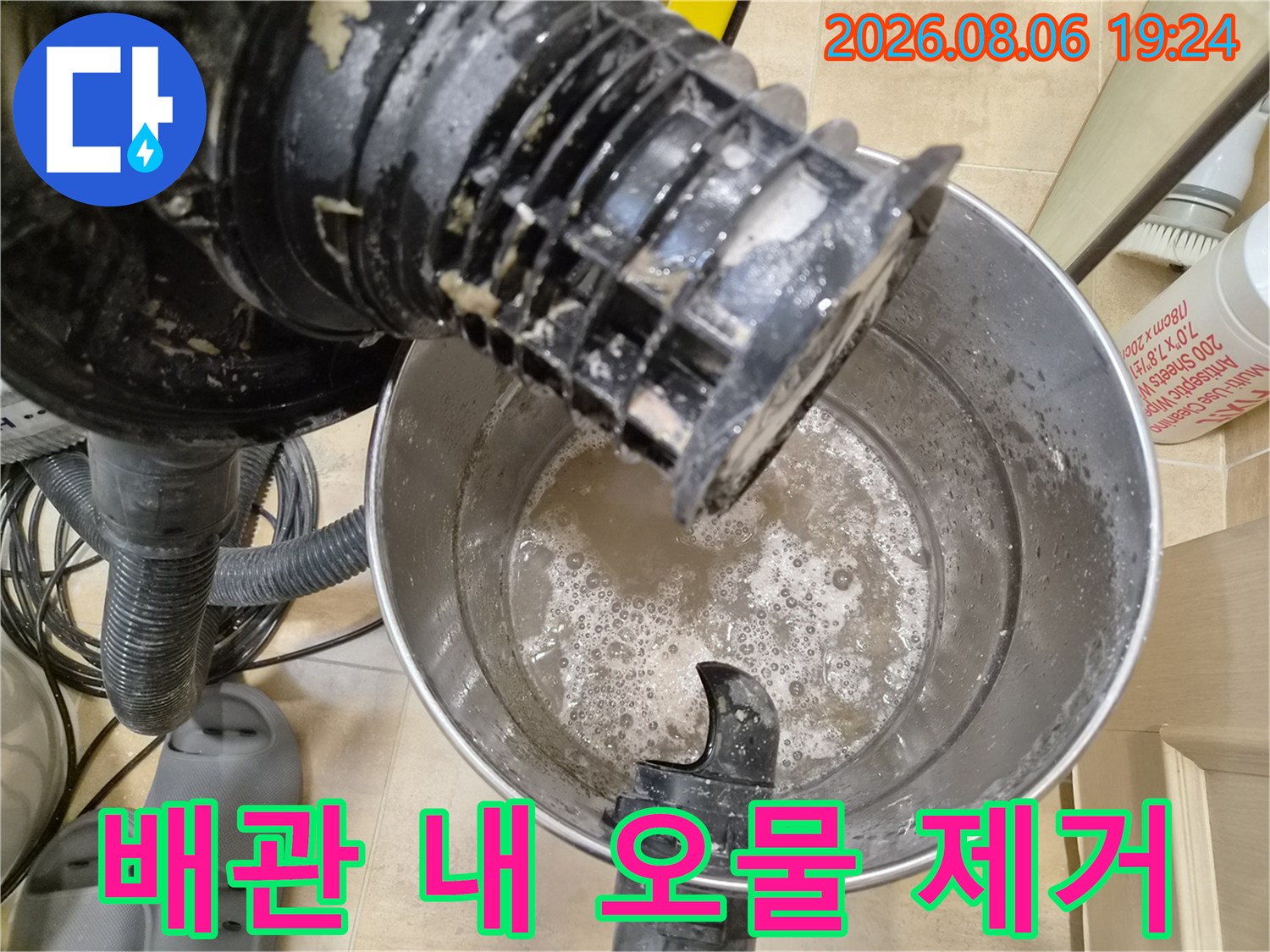 석션 장비 끝단에서-추출된 배수관 이물질과 탁한 물