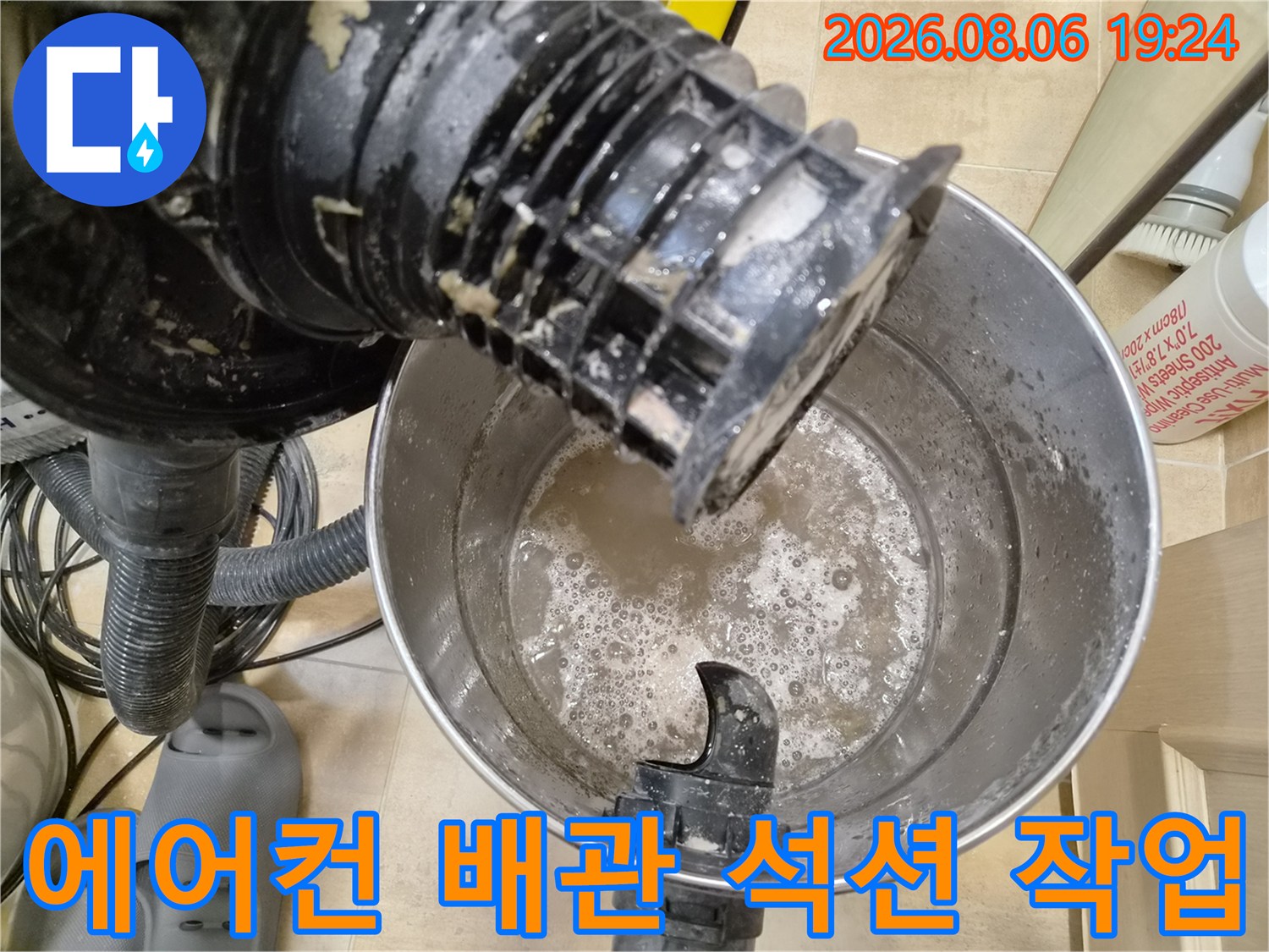 에어컨 드레인 배관에서 이물질을 제거하기 위해 석션 장비를 가동하는 모습입니다.