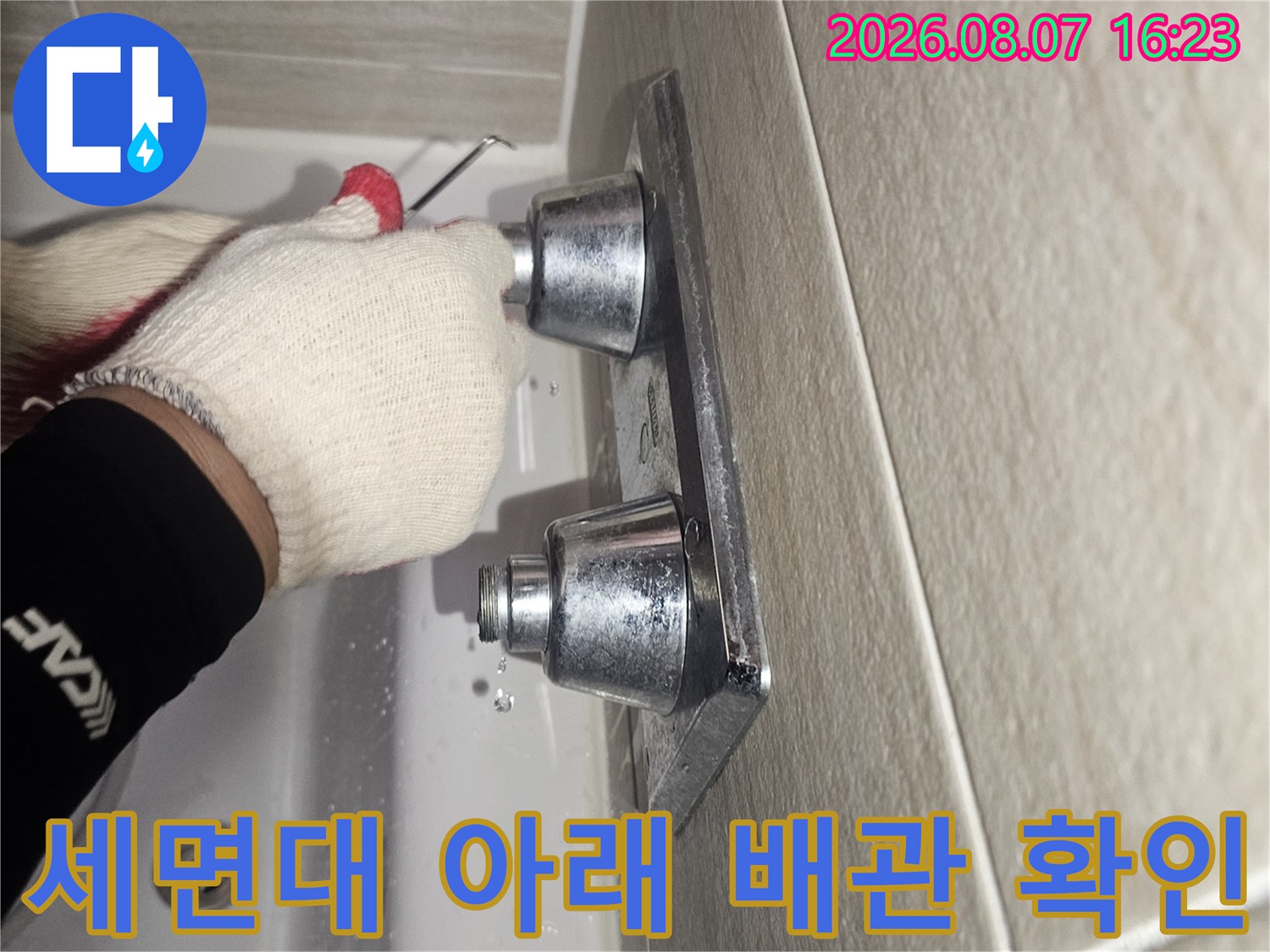 작업자가 장갑을 끼고-세면대 벽면 부속을 점검하는 장면