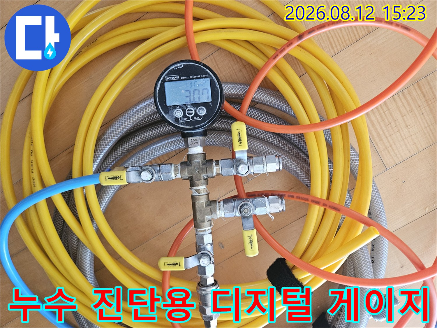 노란색과 파란색 호스가 밸브를 통해 연결된 누수 탐지 전용 압력계