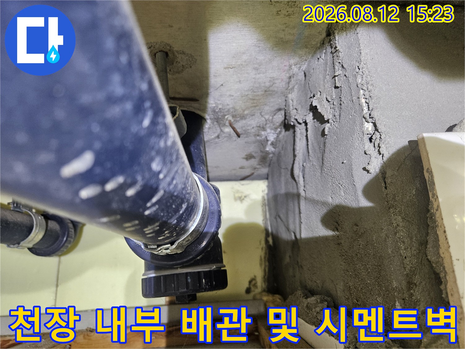 노출된-파란색-PVC-배관과-거칠게-마감된-콘크리트-벽면의-근접-사진