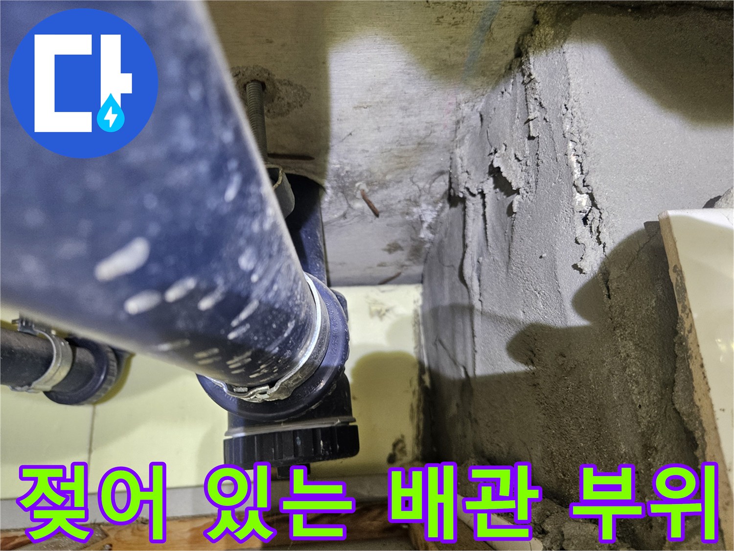 습기가 느껴지는 하수관 연결 소켓과 거친 벽면 구조물