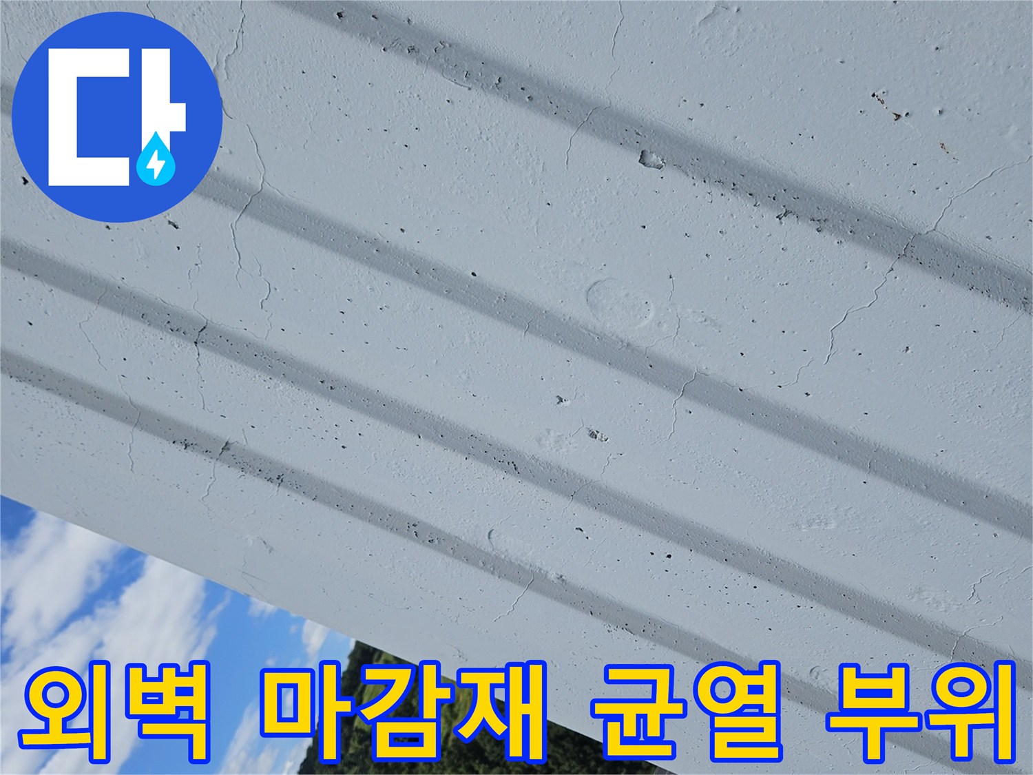 아파트 외부 벽면의 세로 홈과 그 주변에 발생한 미세한 크랙 사진입니다.
