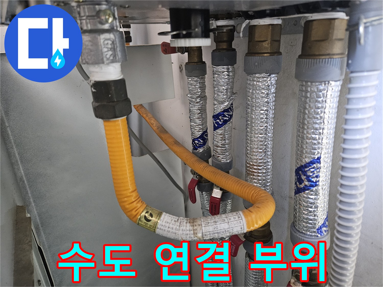 금속 부속과 보온재로 마감된 수도 배관 연결부