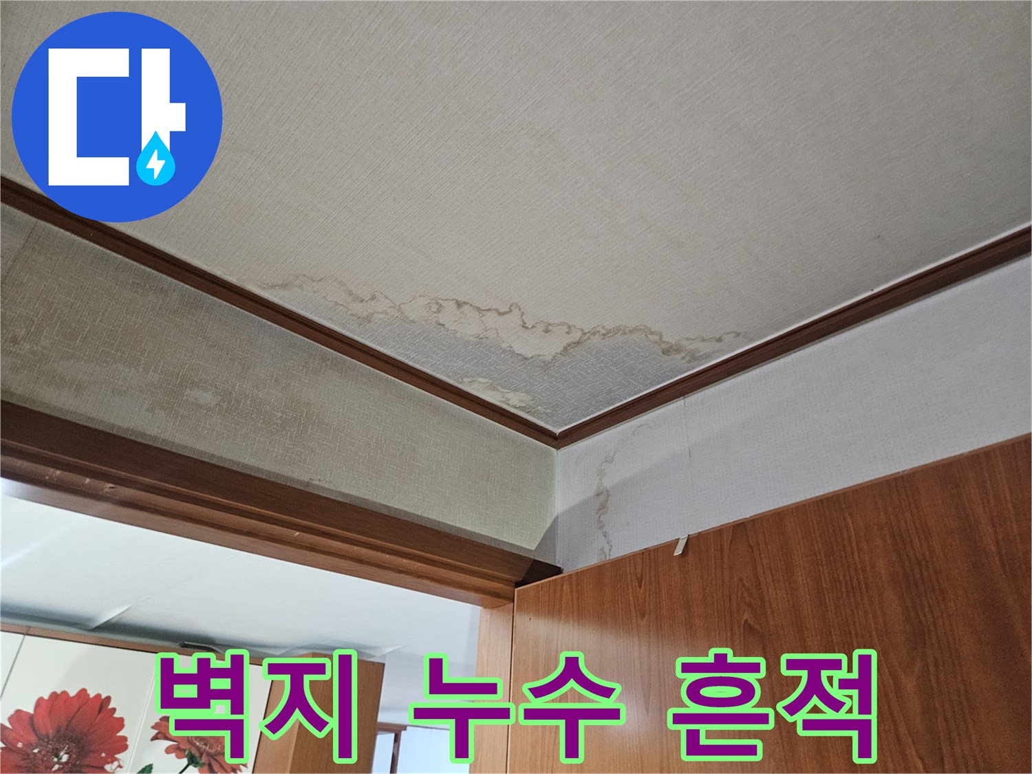 아파트 가구 하단 벽지와 바닥재에 발생한 누수 얼룩 상태입니다.