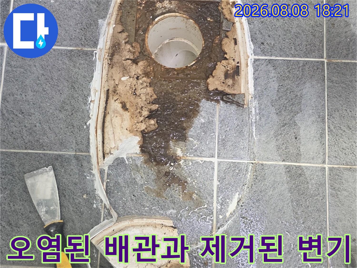 변기 탈거 후 드러난 오염된 배관 입구와 주변 타일