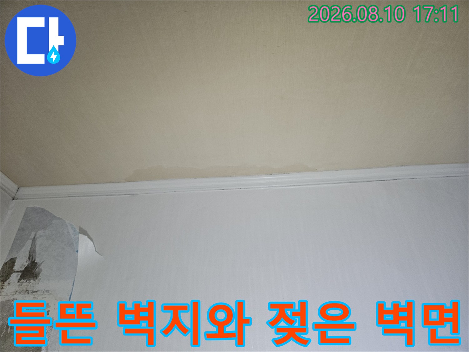 물에 젖어 부풀어 오른 벽지-누수로 인해 손상된 실내 벽면의 모습