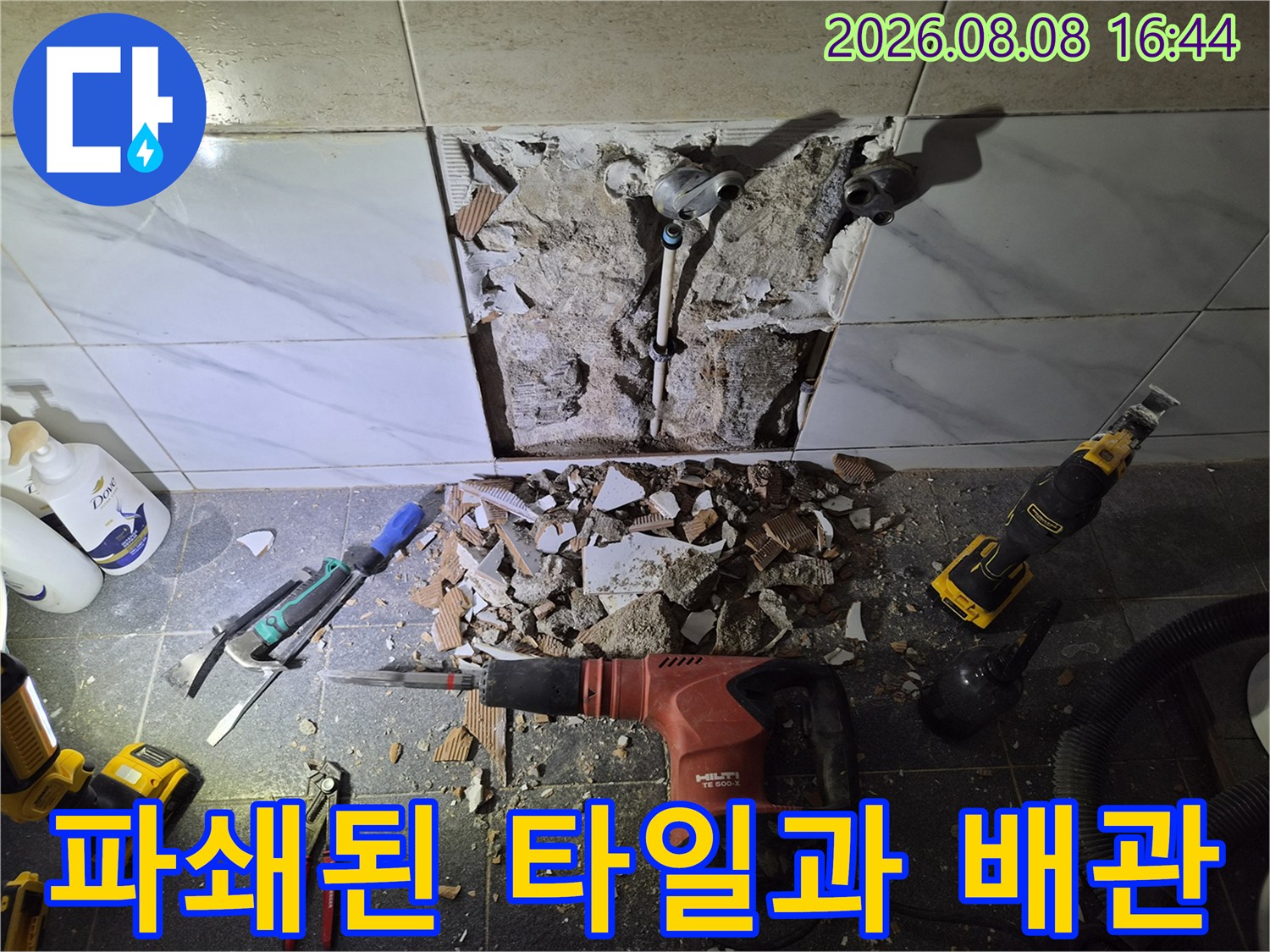 욕실 타일 제거 후 드러난 샤워 수전 연결 부위와 작업 장비