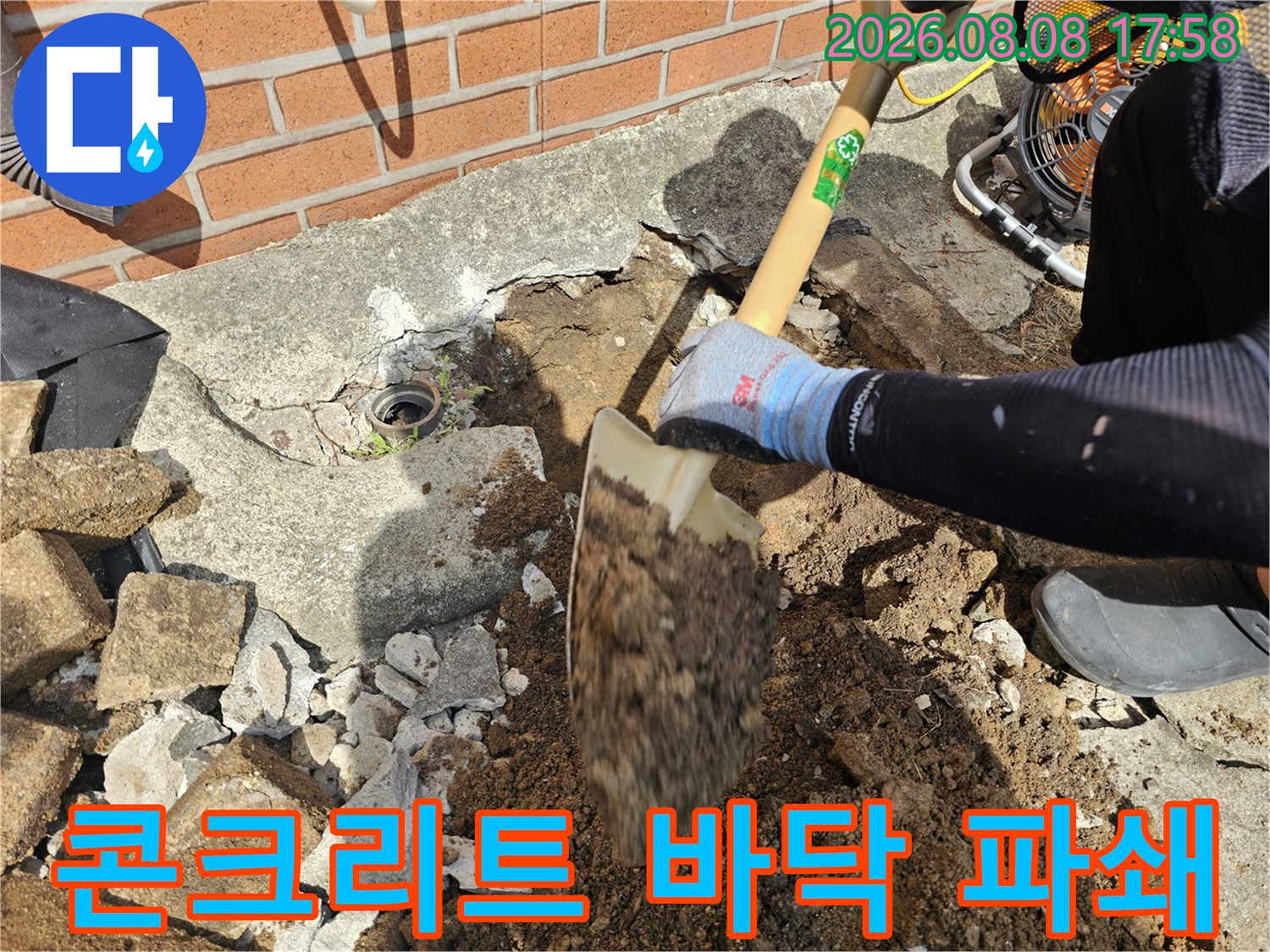 삽을 사용하여 콘크리트와 흙을 제거하는 작업자 모습