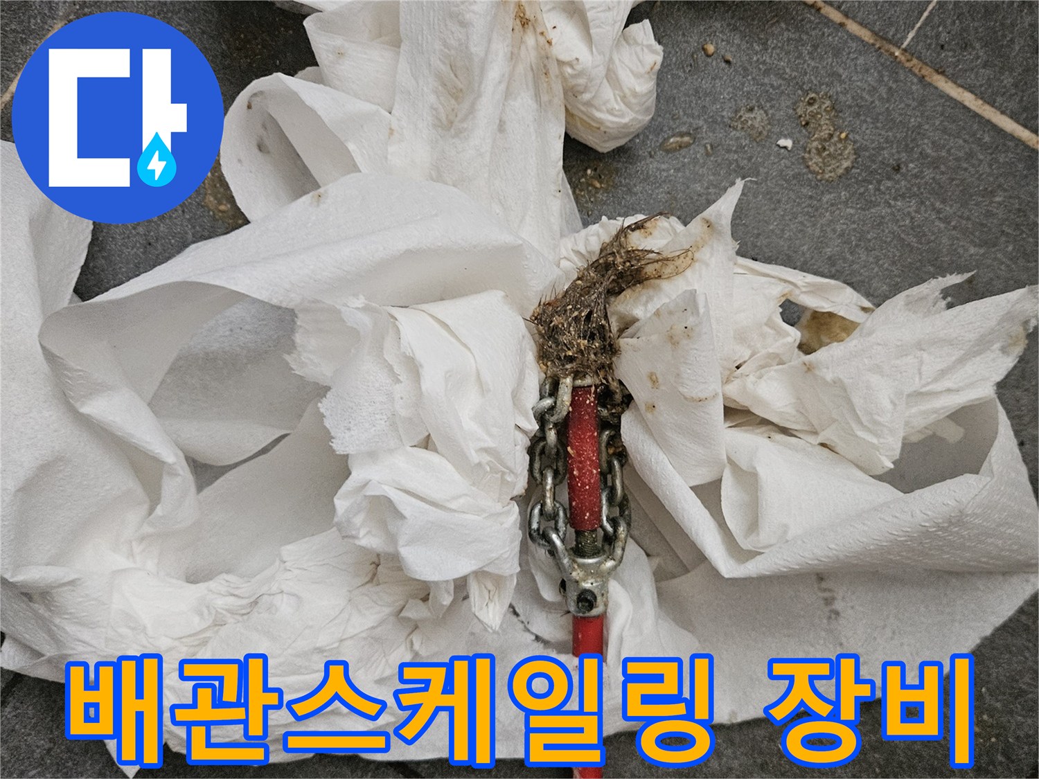 배관 내부의 이물질을 제거하기 위해 사용된 전동 스프링 장비와 오물이 묻은 키친타월
