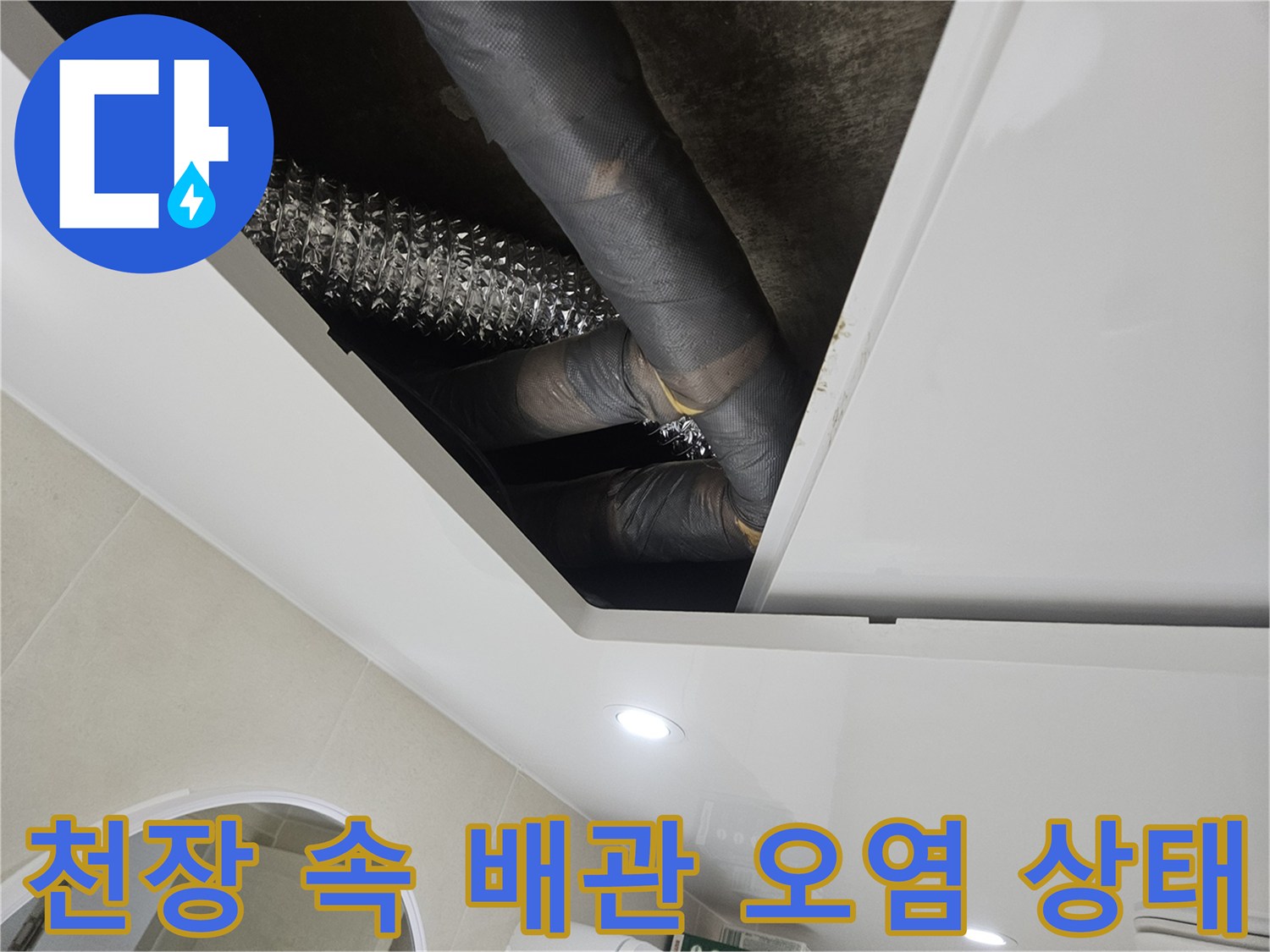 오염된-회색-단열재-배관과-은색-주름관이-보이는-천장-내부