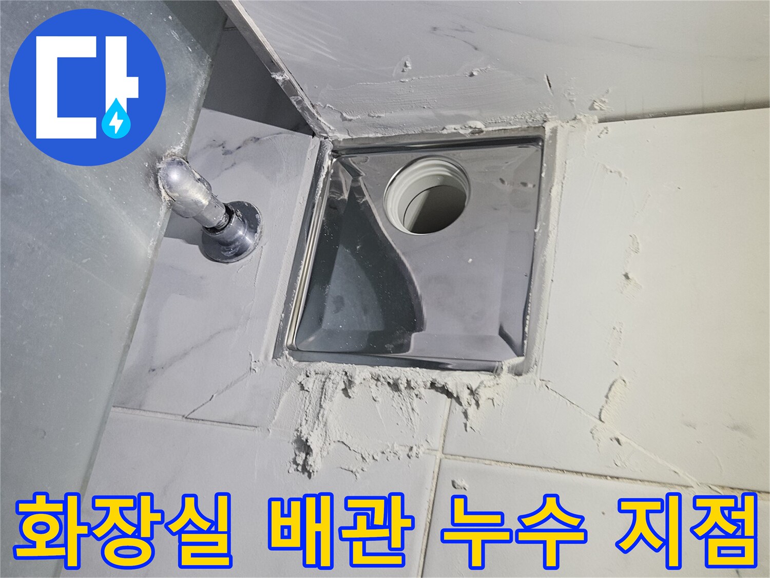 욕실-타일-벽면의-금속-점검구를-통해-노출된-배관-연결부의-모습
