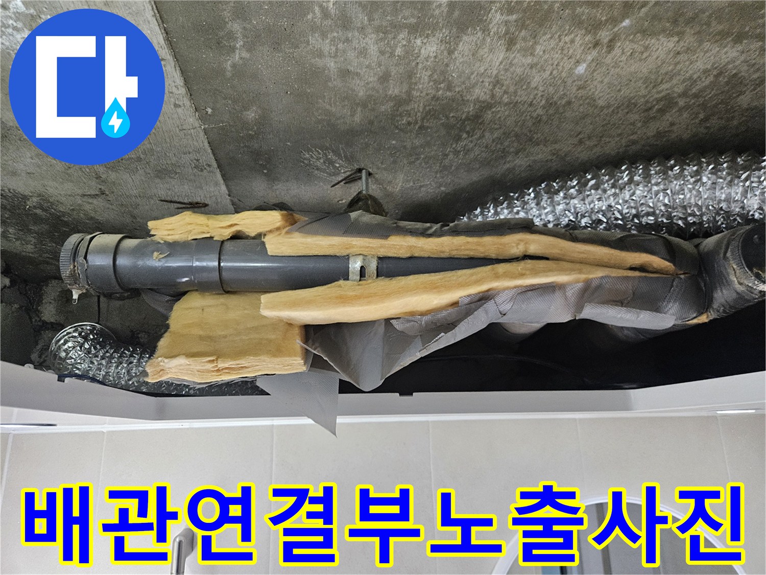 회색-배관과-벗겨진-노란색-보온재가-보이는-천장-내부