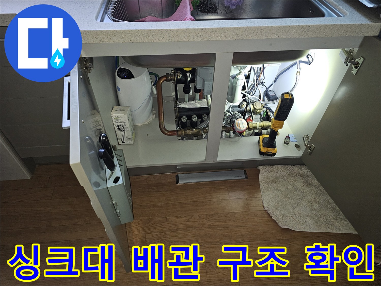 싱크대 아래쪽 수도 부품과 점검용 전동 공구