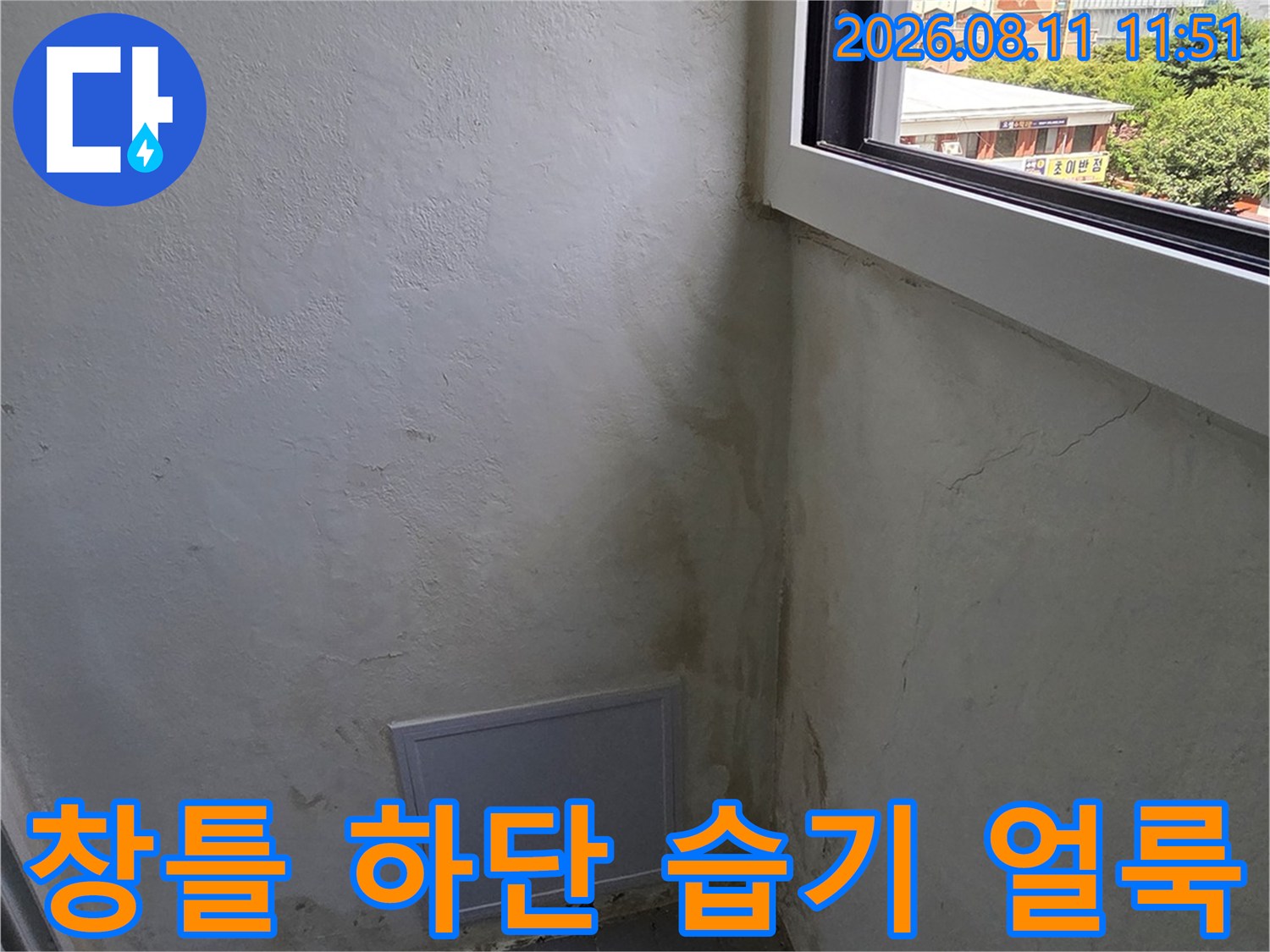 창문 아래 벽면의 어두운 습기 자국과 곰팡이 발생 부위입니다.