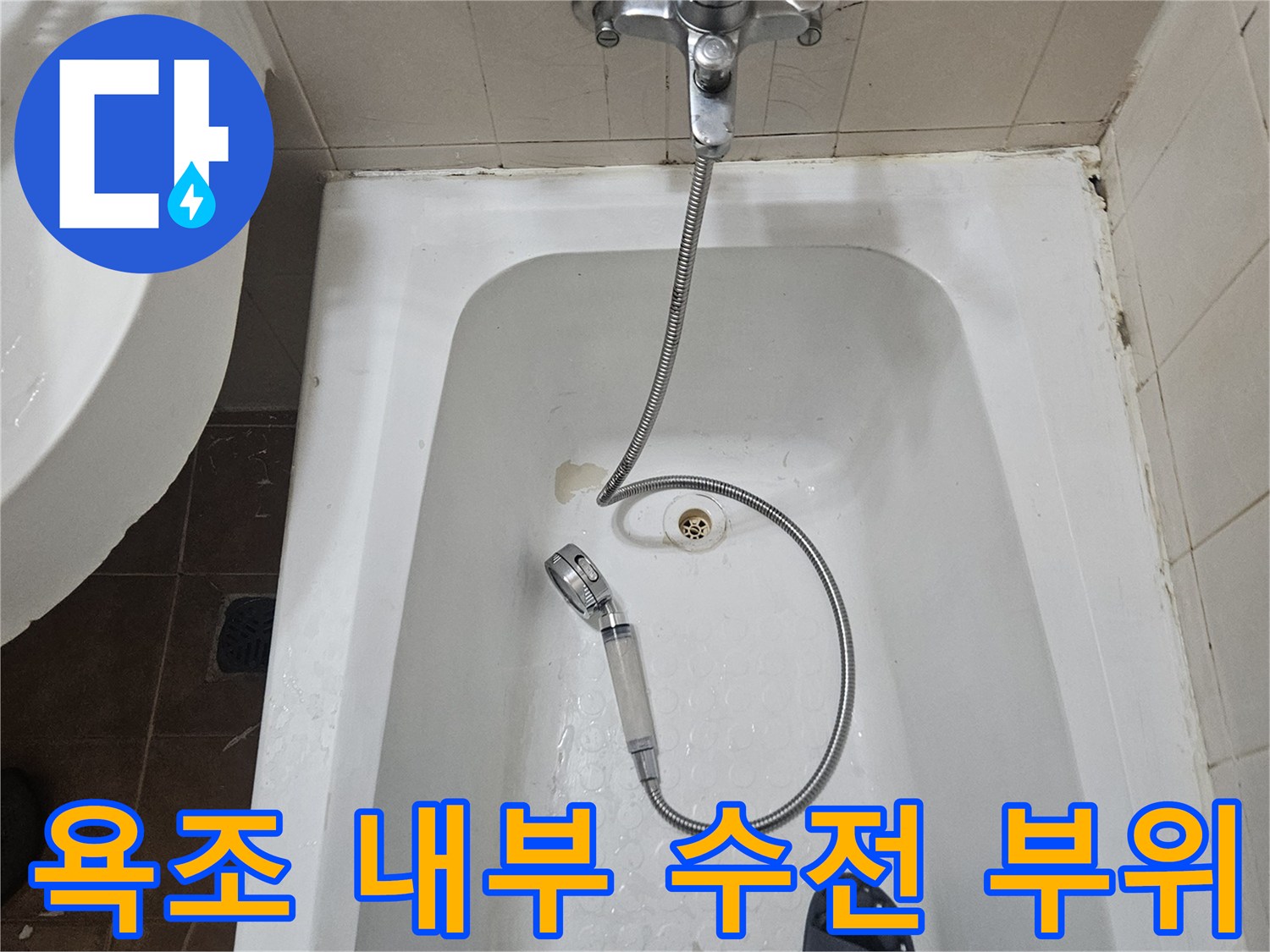 욕조 안쪽 샤워기 호스와 배수구 입구 모습