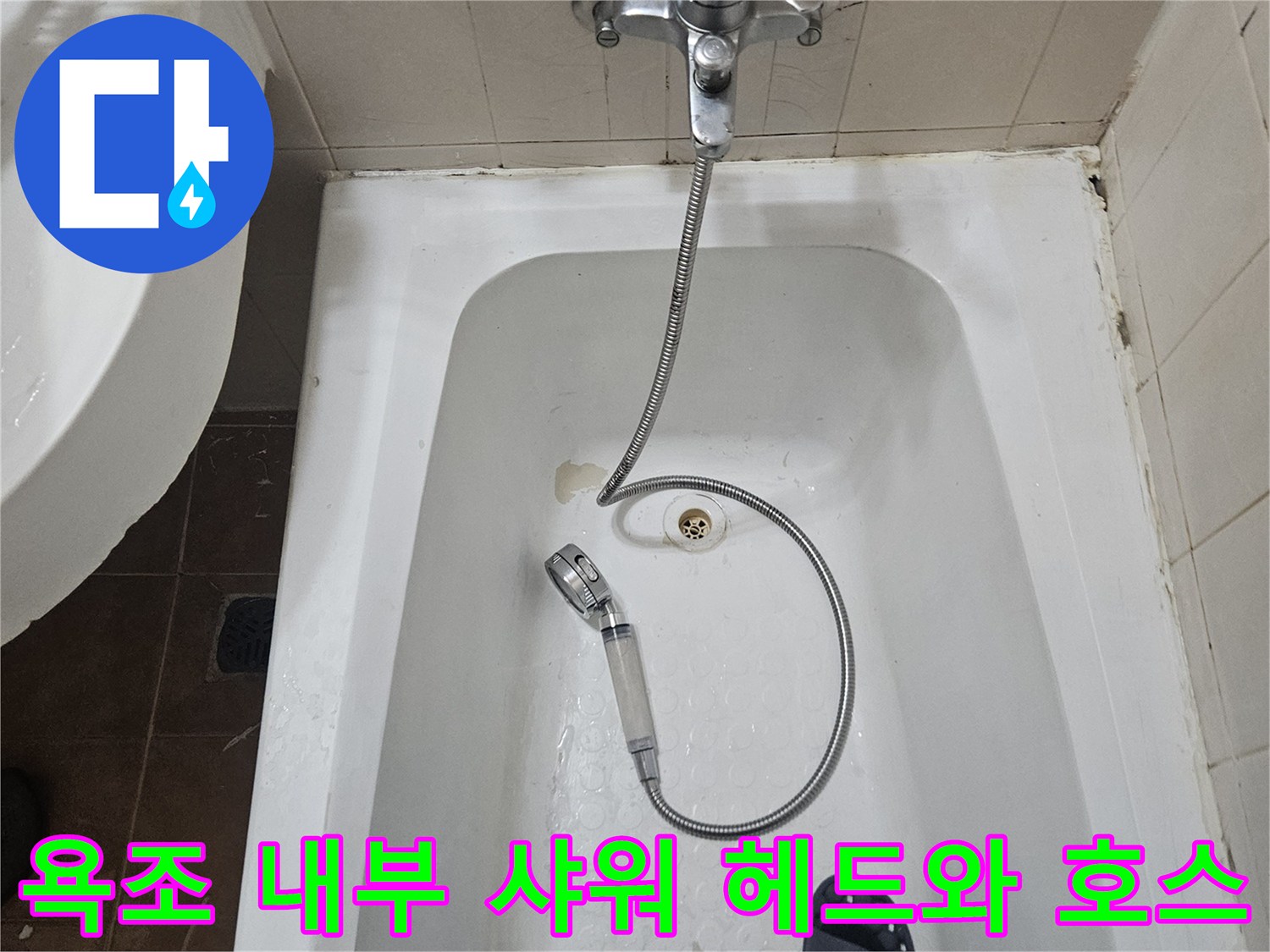 욕조 안쪽의 은색 수전과 연결된 샤워기 호스