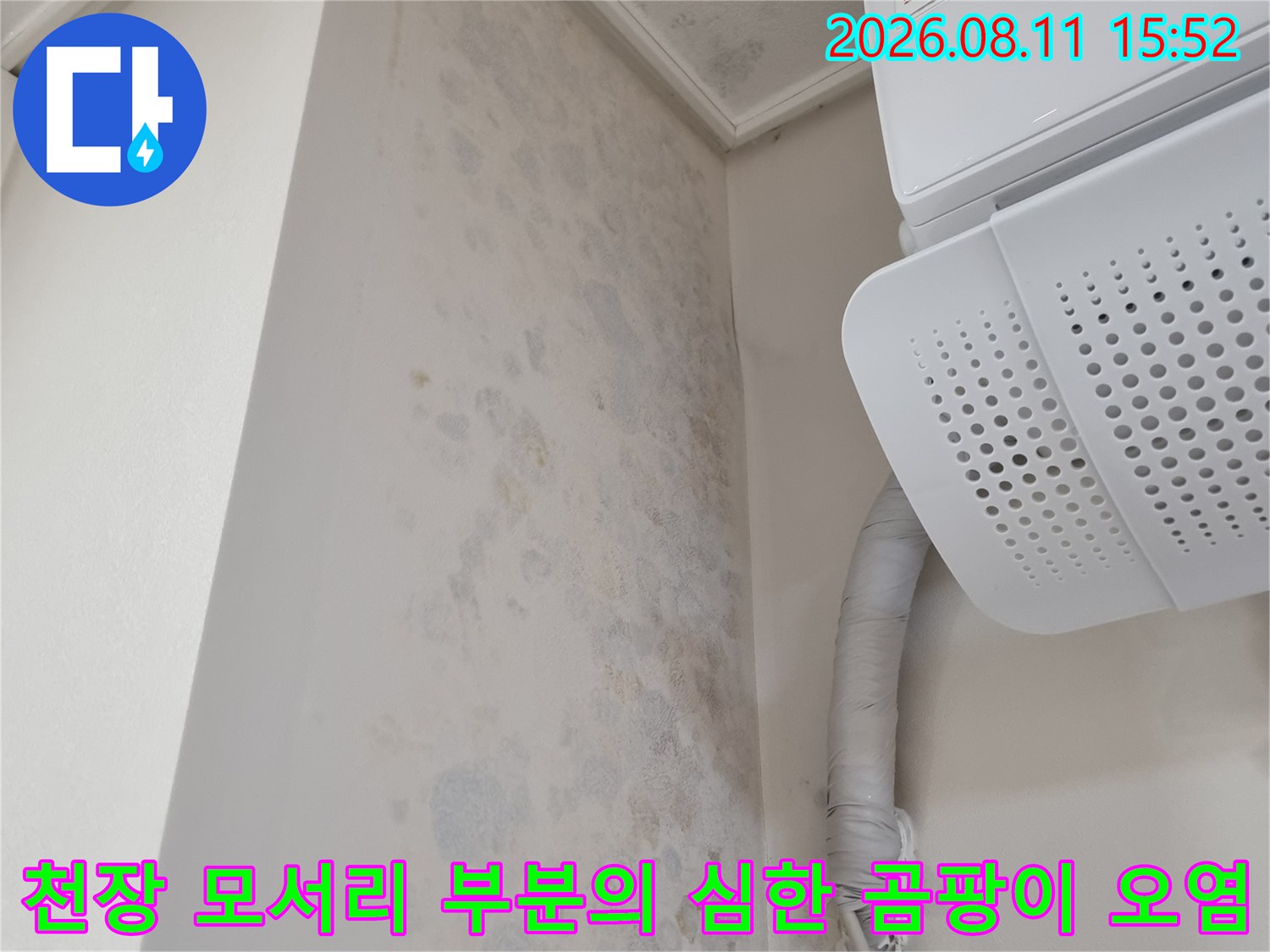 에어컨 실내기와 벽체가 만나는 지점에 발생한 회색과 푸른색의 누수 얼룩 및 배관 라인