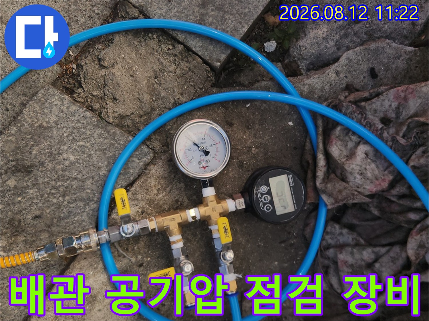 배관에 연결된 파란색 호스와 압력 게이지 사진