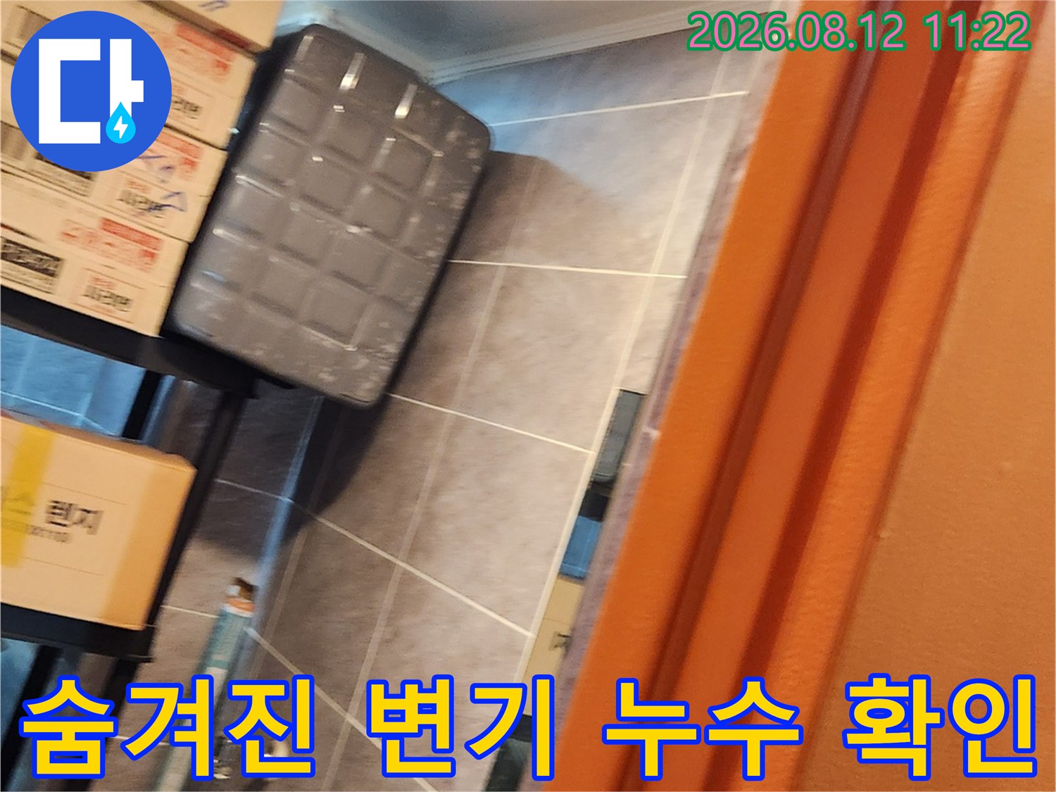 창고 구석에 위치한 변기와 주변의 타일 벽면을 촬영한 사진입니다.