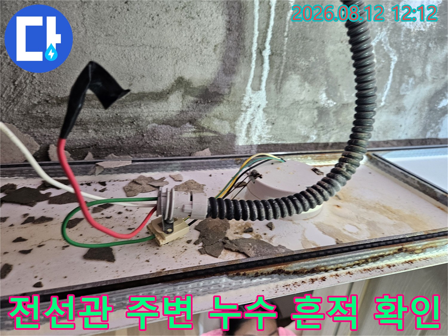 천장 내부 배관과 전선 주위의 물 자국 및 콘크리트 얼룩을 보여주는 이미지입니다.
