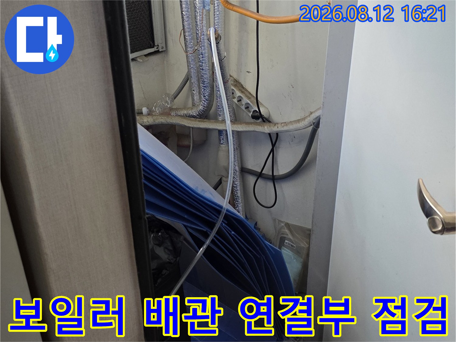 흰색 보일러 본체와 연결된 은색 단열재 배관-노란색 전선이 함께 배치된 모습