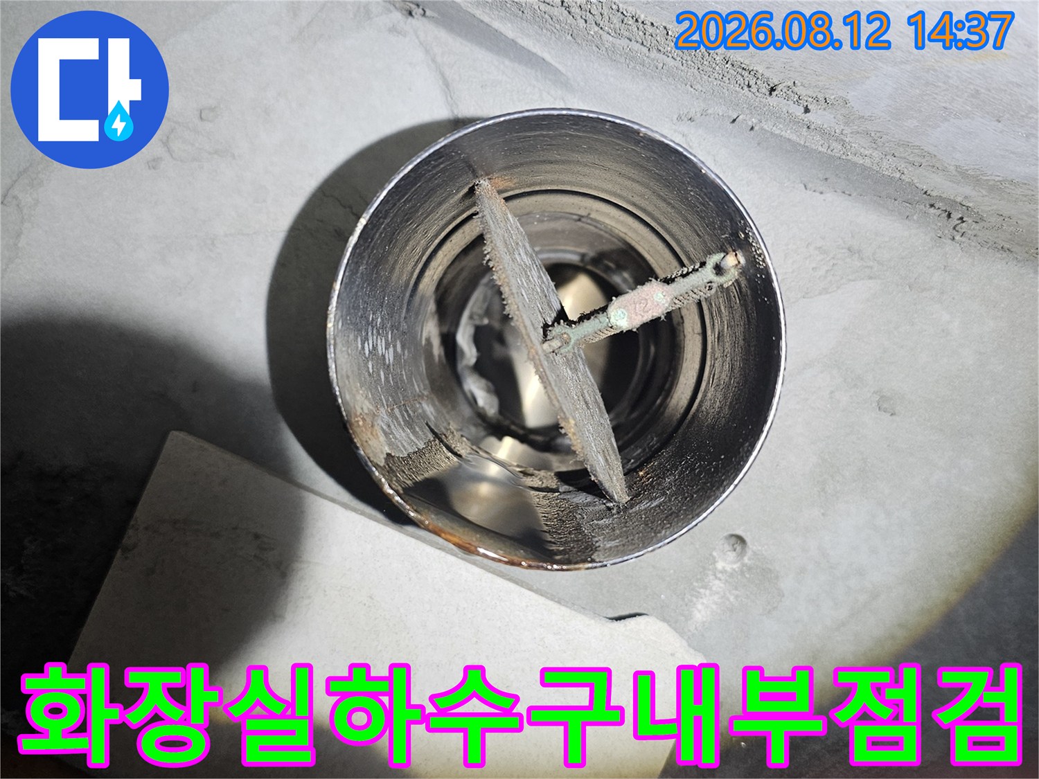 금속-재질의-하수-배관-입구와-그-안쪽의-교차형-부품을-찍은-사진