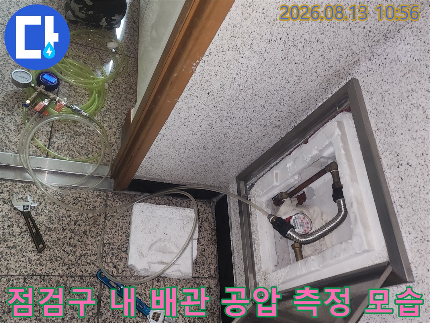 배관 연결 부위에 디지털 압력계를 설치하고 주변에 작업 도구를 배치한 사진