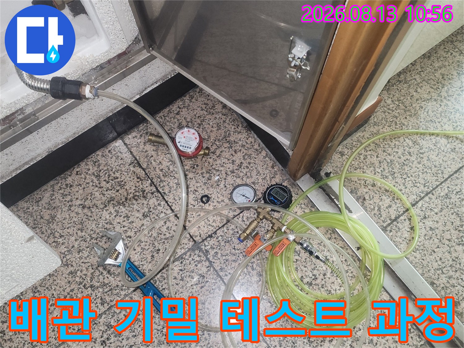 스테인리스 점검구 하단에 설치된 누수 측정 장비와 렌치-작업 준비 상태