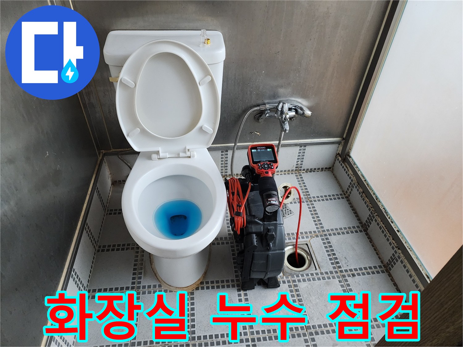 변기 내부의 푸른 물과 옆에 놓인 배관 점검 장비의 모습입니다.