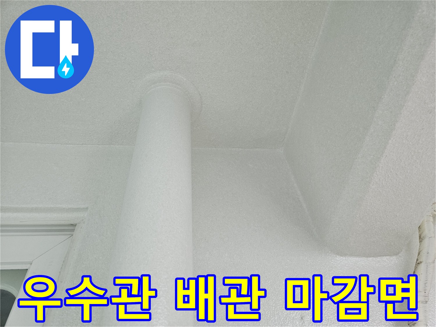 하얀색 우수관과-천장 마감재가 연결된 부위의 근접 촬영입니다.