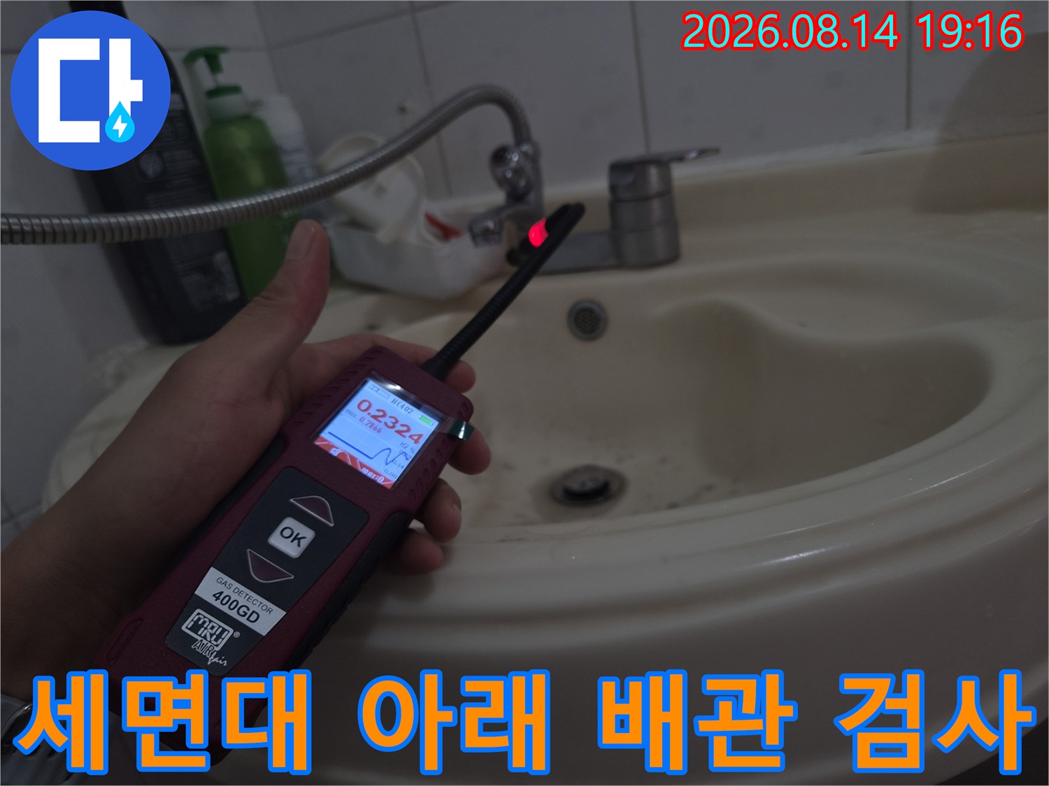 손으로 들고 있는-가스 탐지기가-세면대 하단 배관을 향하고 있음