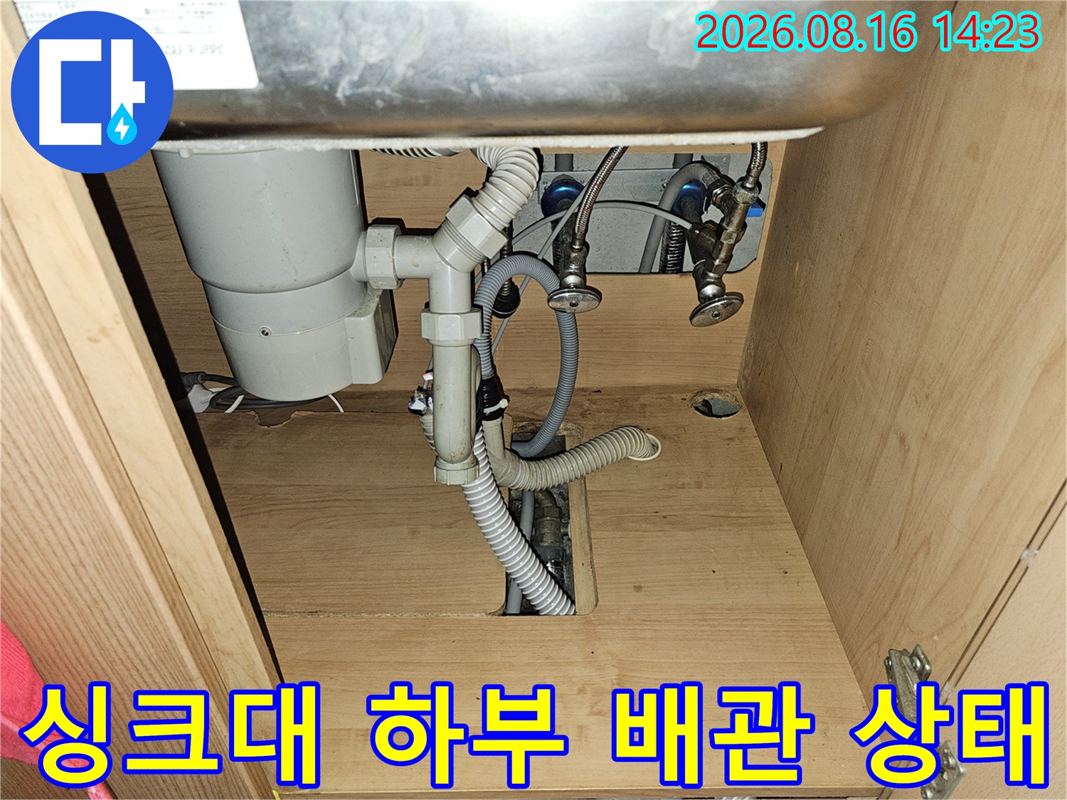 주방 싱크대 하부장 내부의 하수 배관과 급수 밸브 연결 부위