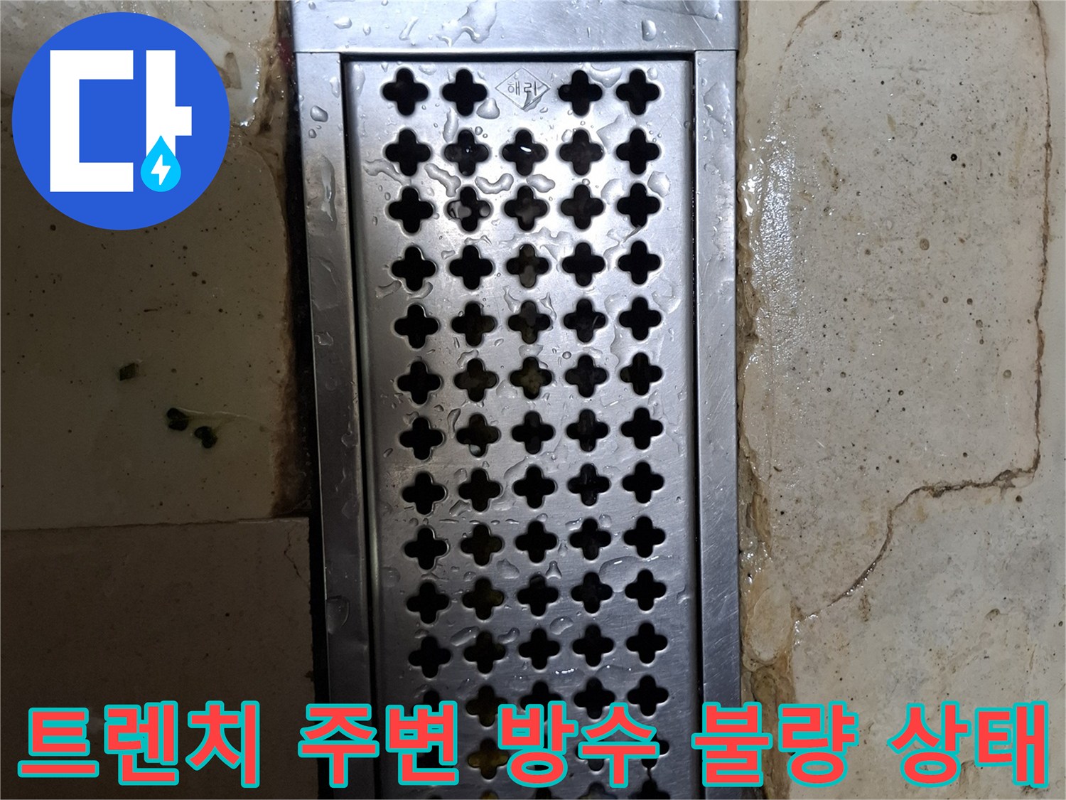 물기가 머물러 있는 스테인리스 배수 트렌치와 타일 경계부