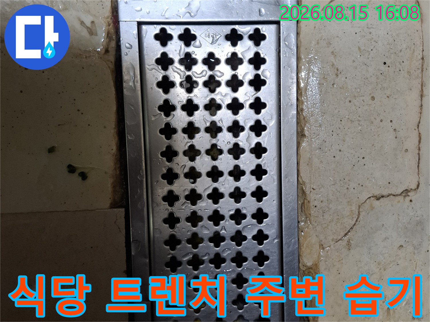 물기가 스며 나온 스테인리스 트렌치와 타일 사이의 모습